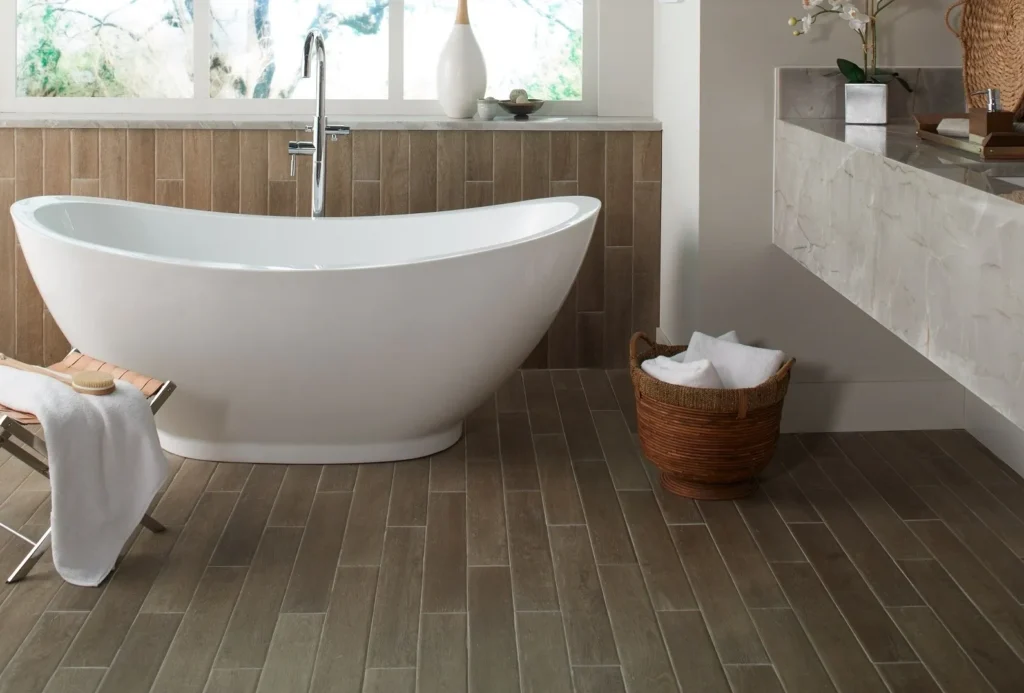 A bathroom with a tub and wooden floor